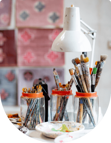art brushes in glass jars and art palettes on the table